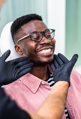Dentist looking at smiling patient’s teeth